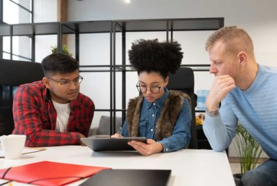 Three people looking at a tablet