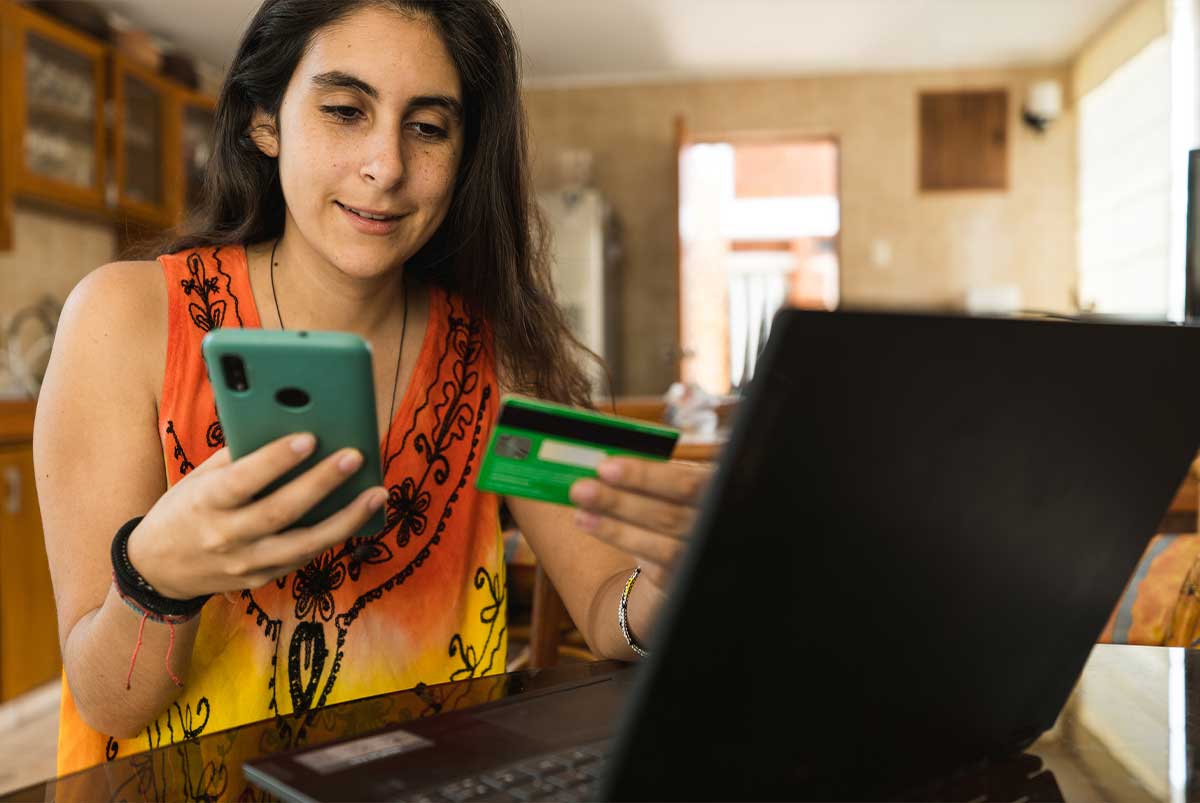 Young woman using phone and credit card