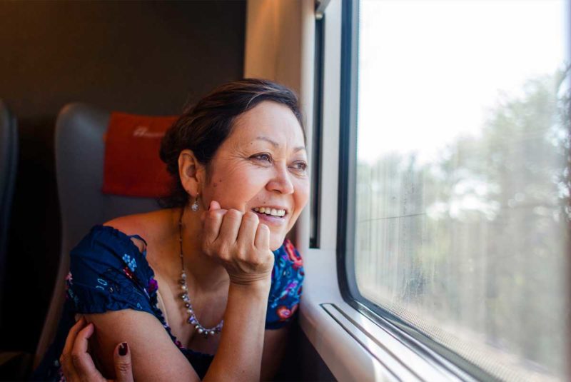 Woman looking out window on train