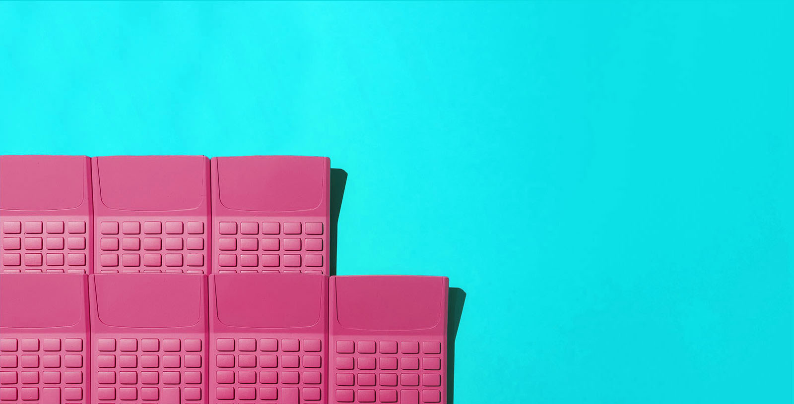 a group of pink calculators on a cyan background