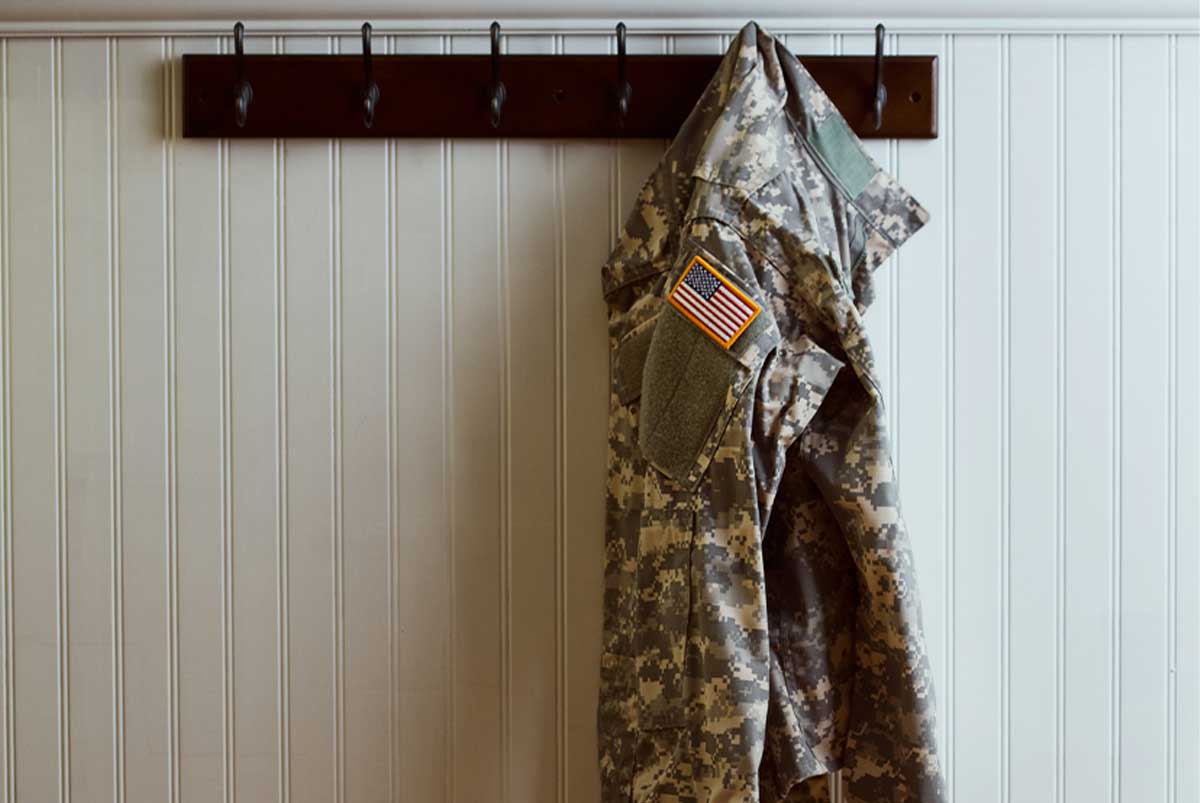 A veteran's uniform hangs on a coat rack.