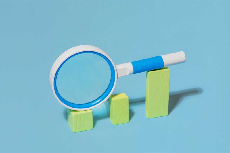 A conceptual image me of a magnifying glass over a bar chart, meant to represent waiving the contingency.