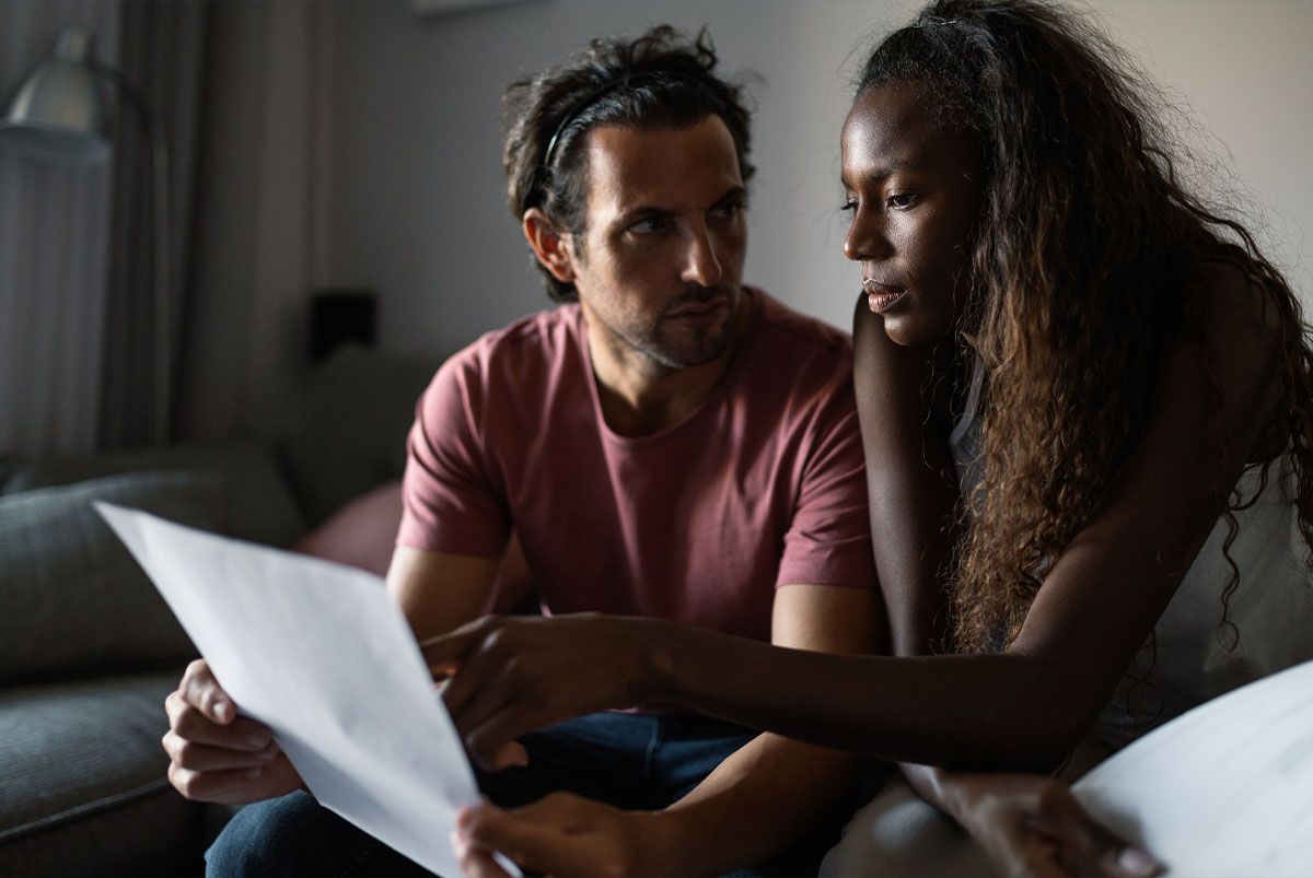 couple looking at paper with debt information