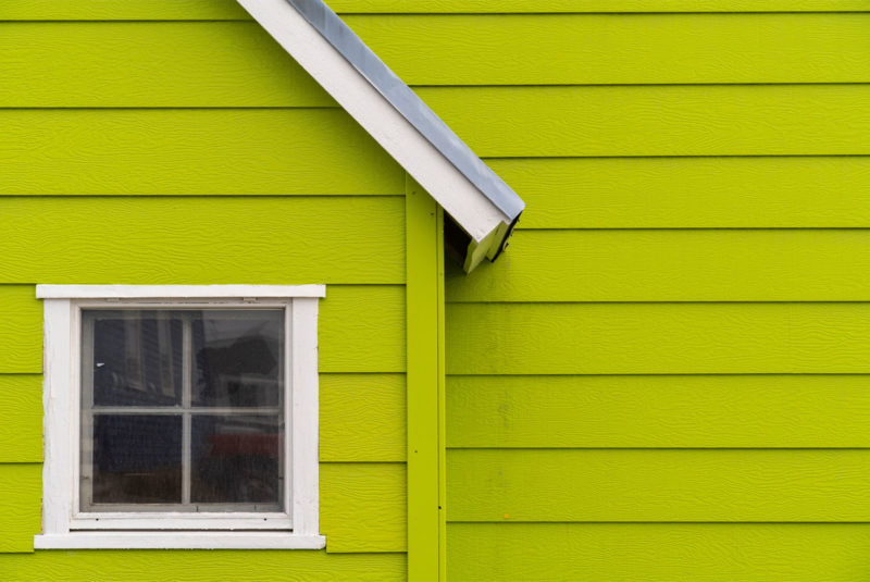 Bright green house with square window reflecting fixer upper topic