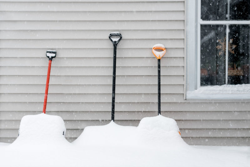 Three snow shovels covered in snow