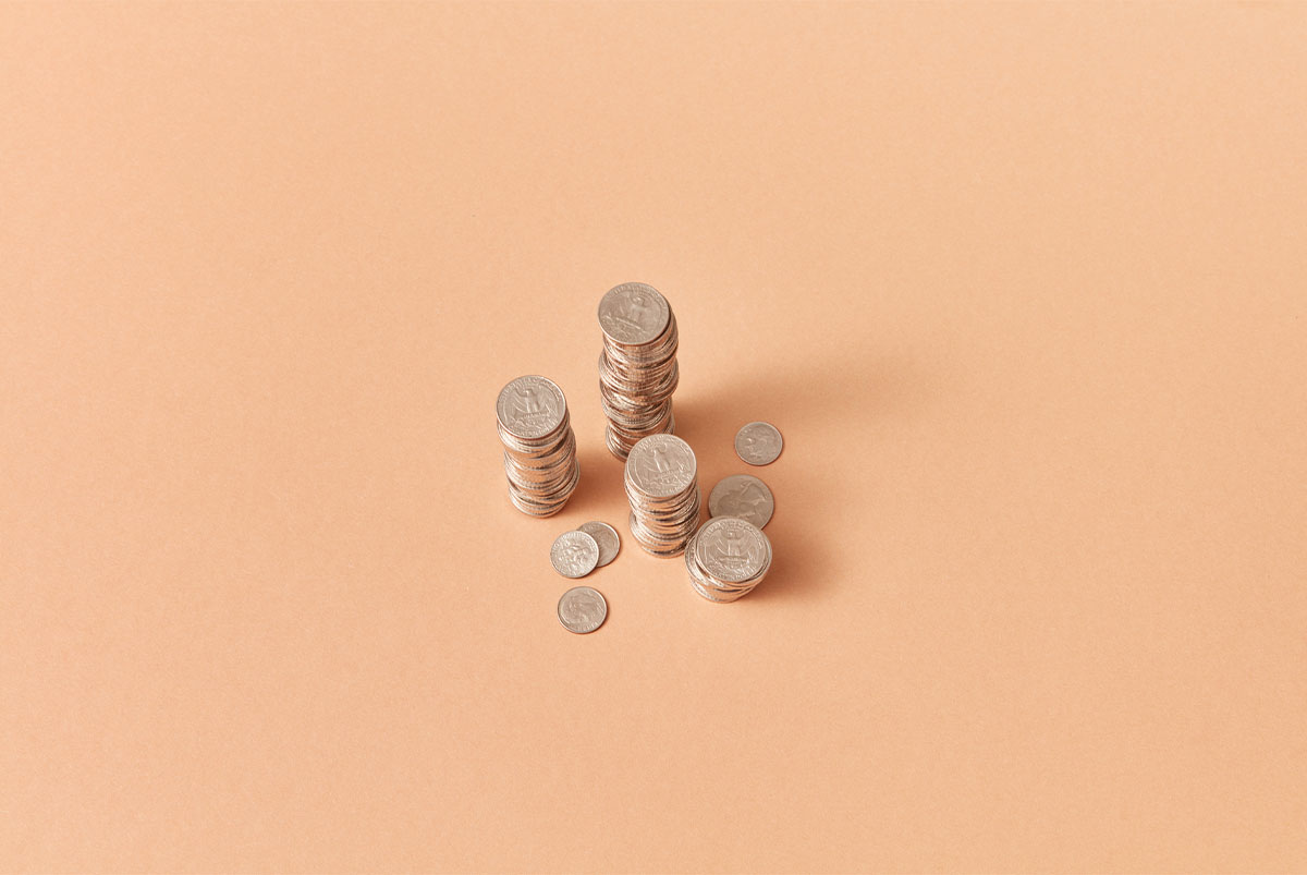 Stacks of coins on coral background