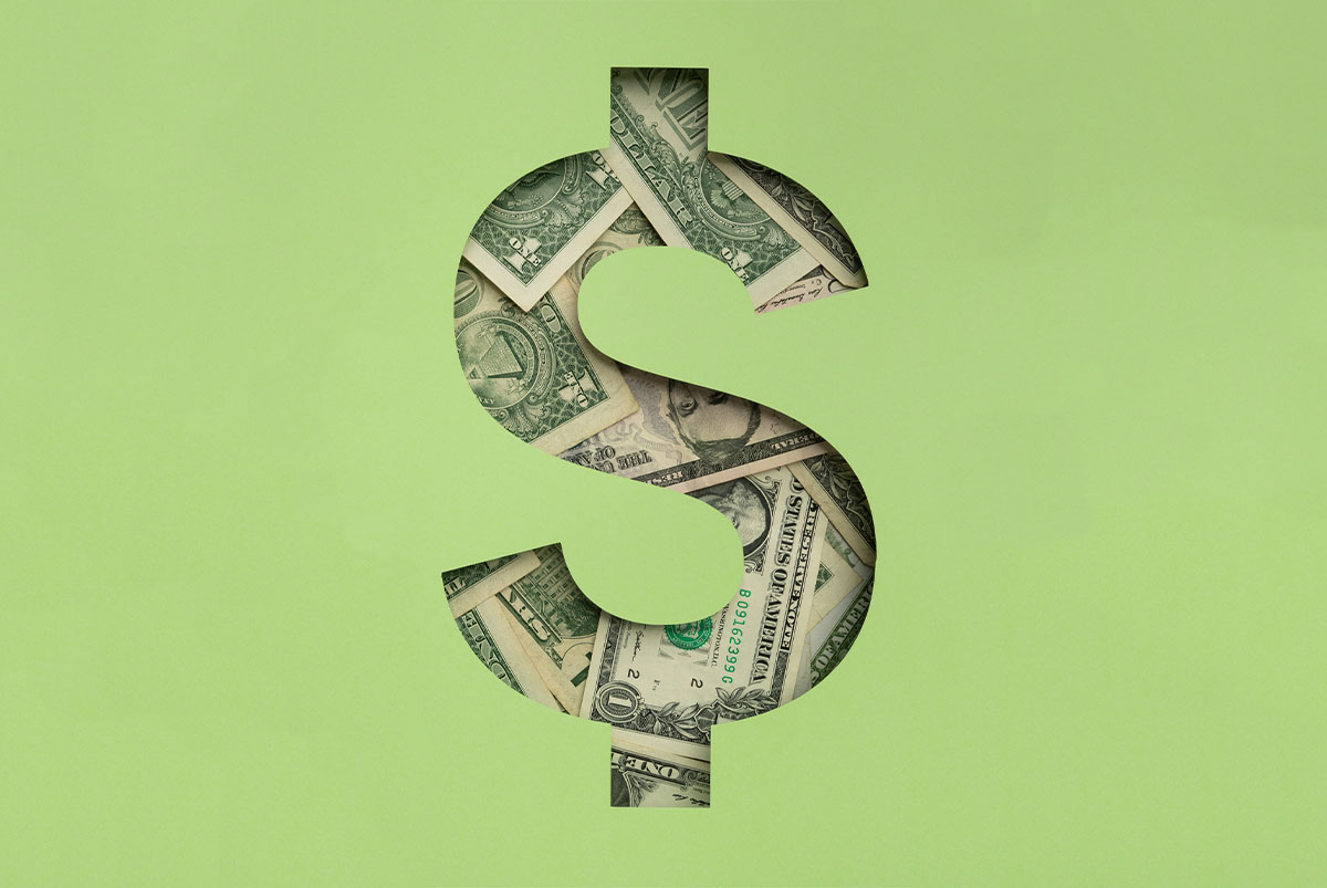 dollar sign cutout of green foreground, dollar bills in the background