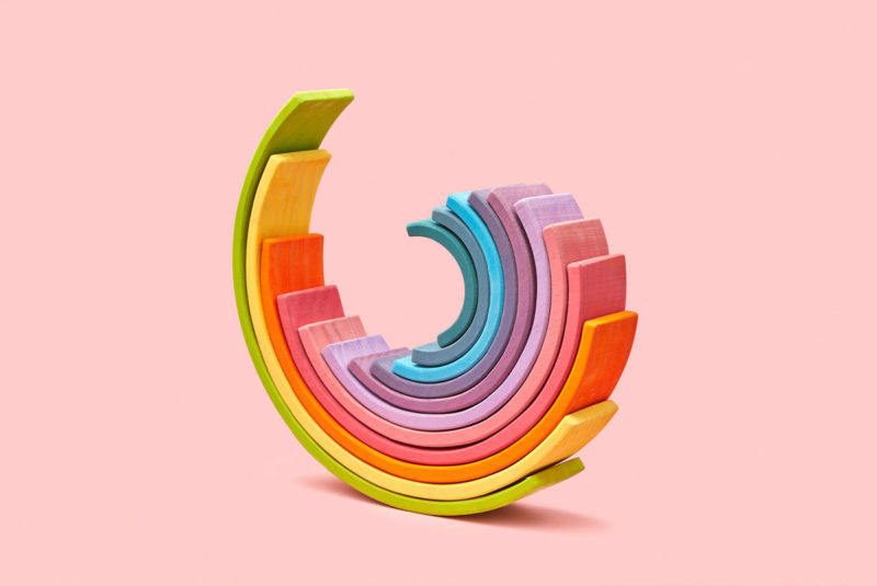 Pink background with strips of color rolling into a semi circle