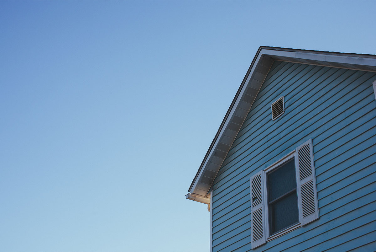 Side of blue house with vinyl siding