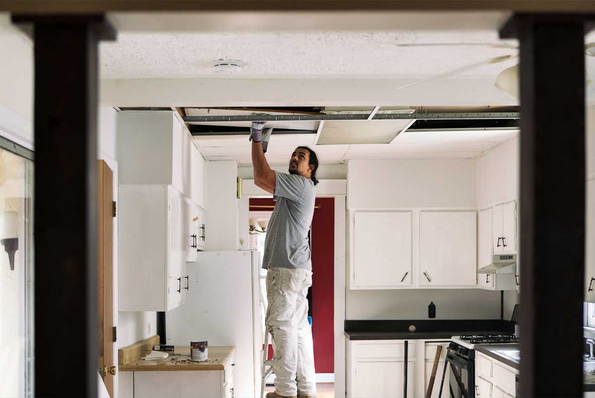 Person making repairs to kitchen ceiling