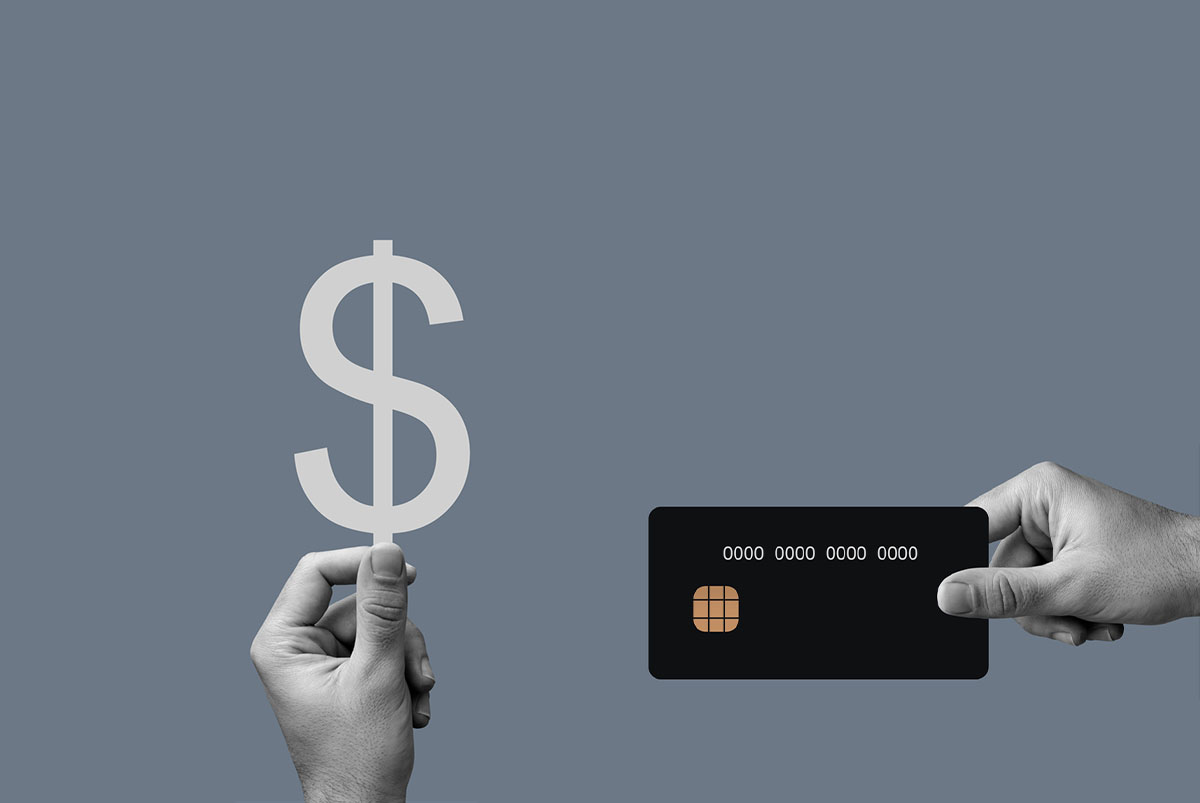 Conceptual image of cash sign and credit card side-by-side.