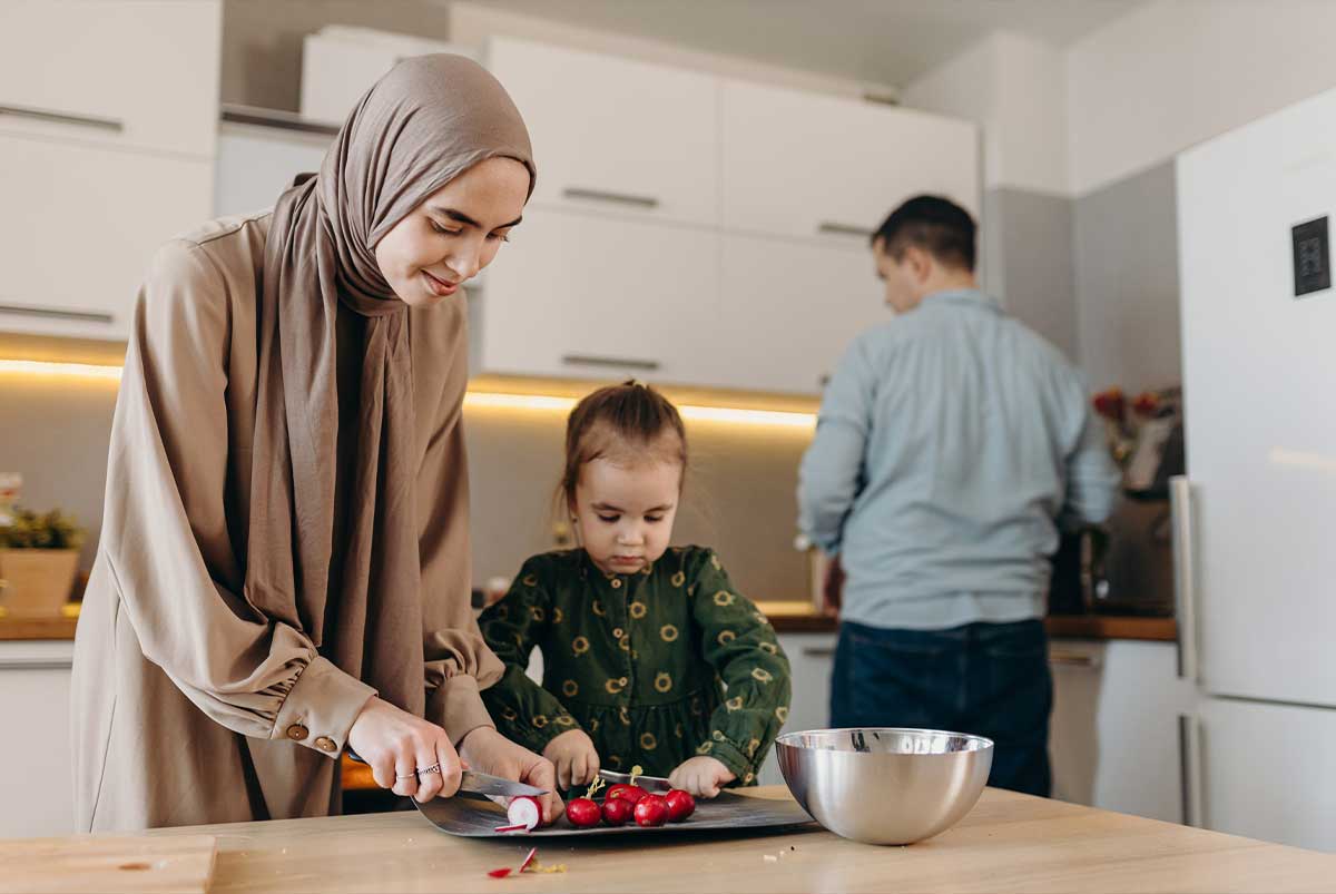Woman with headscarf and family preparing dinner