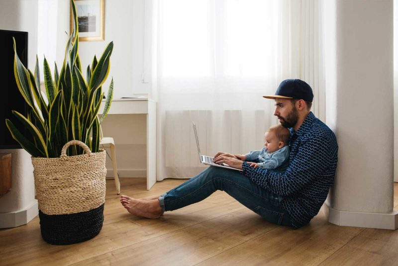 Man on floor with laptop and child