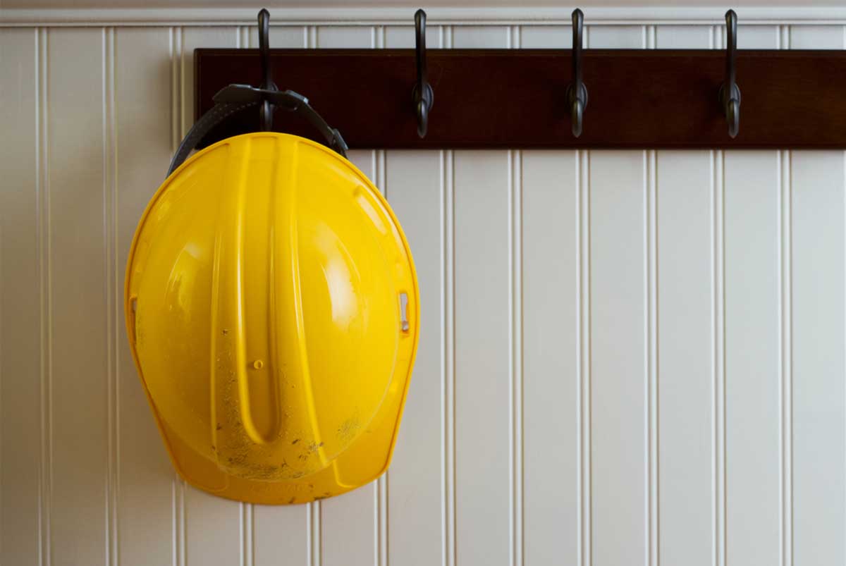 A yellow construction helmet hanging on a hook