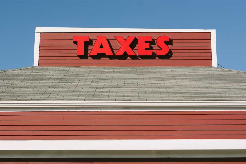 Rooftop sign with "TAXES" in red letters