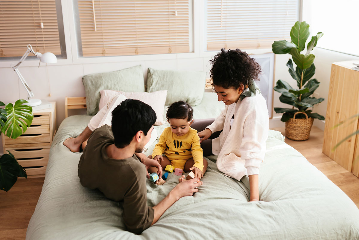 Parents playing with child on bed