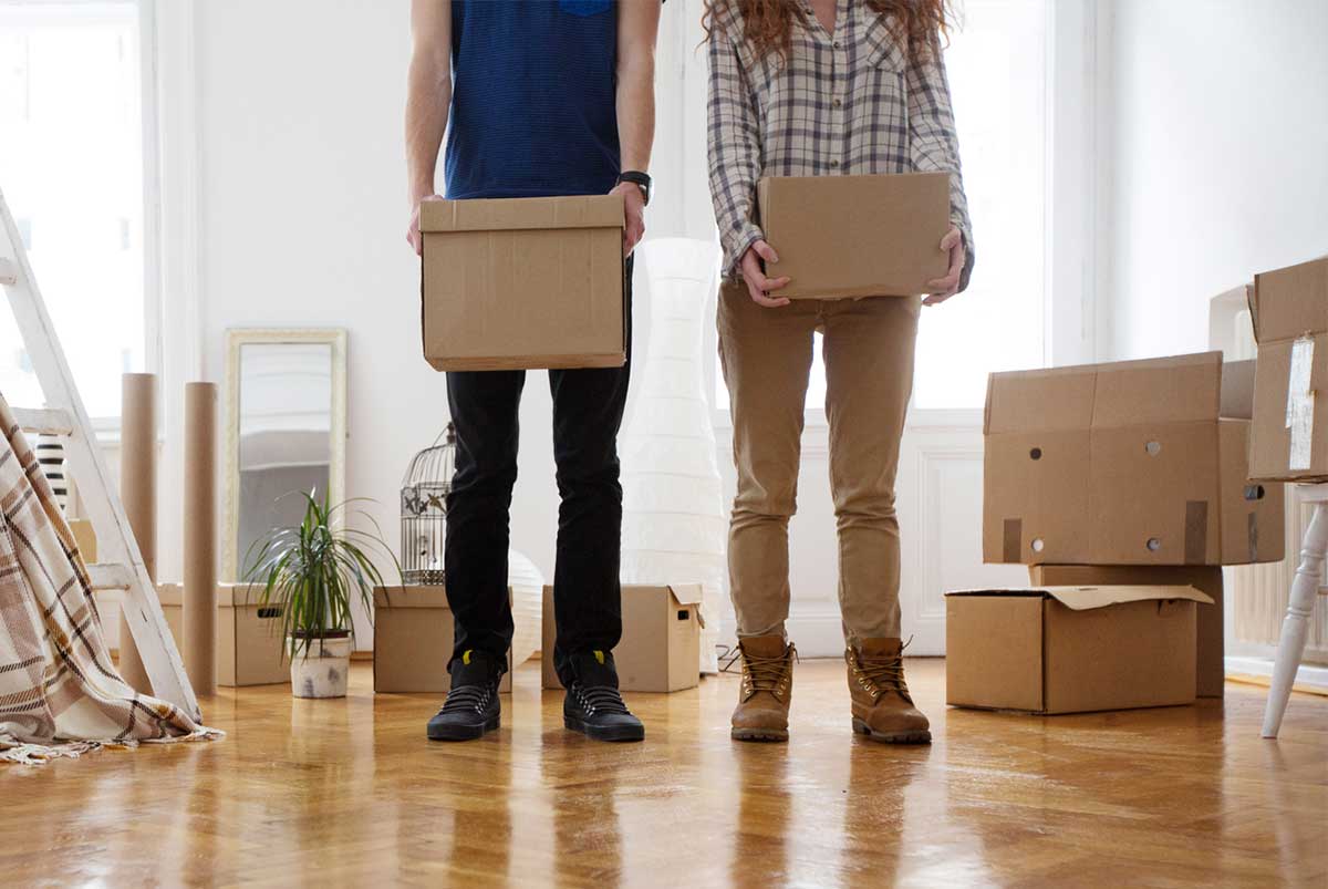 Two people holding cardboard boxes