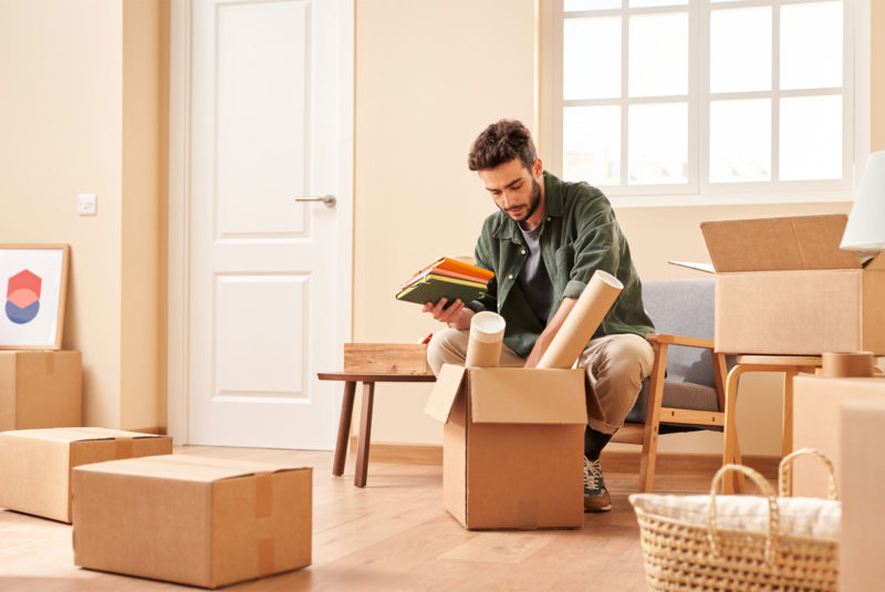 Man opening boxes in his apartment wondering what adjustable rate mortgages are