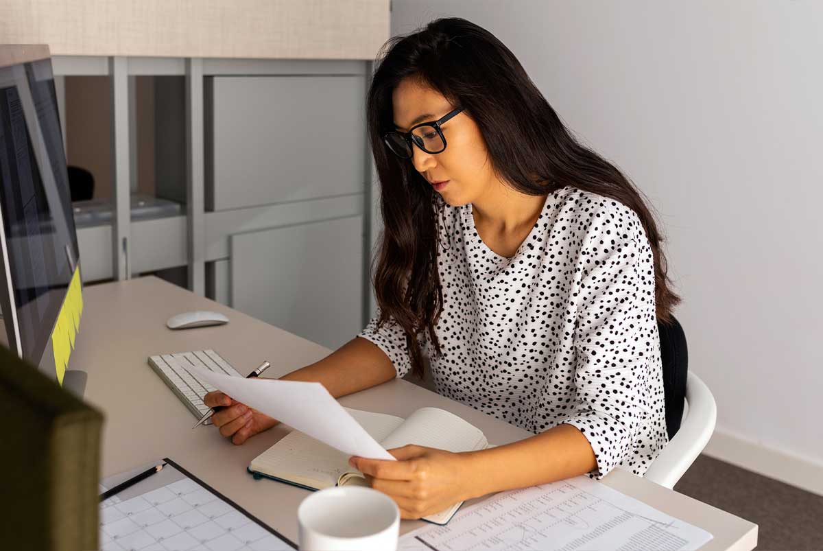 Processor working on paperwork at a desk.