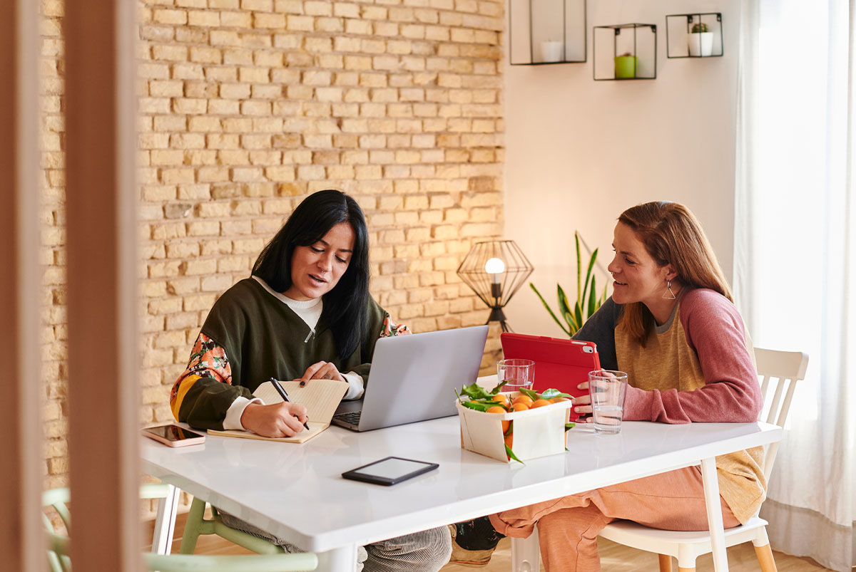 Two people working at a home desk