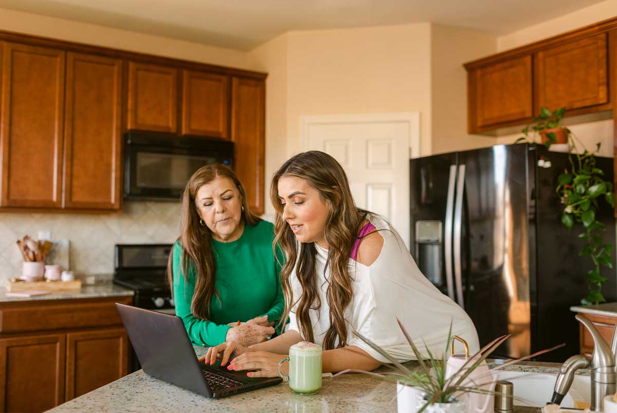 Two women on a laptop in the kitchen