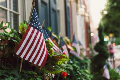 A row of American flags in front of townhomes.