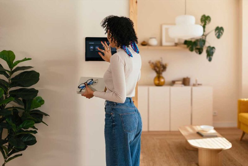Uma mulher ajusta o termostato em sua casa