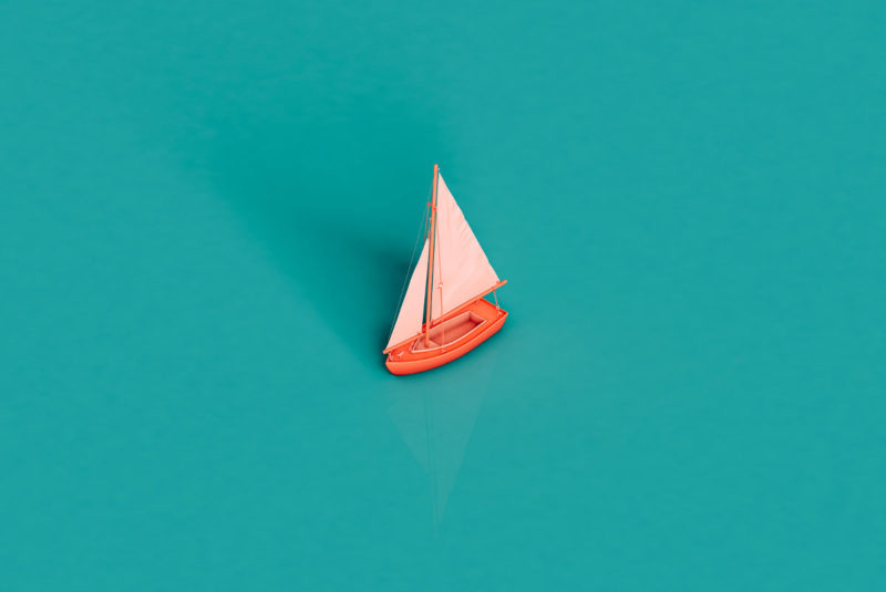 Toy sailboat on a teal background