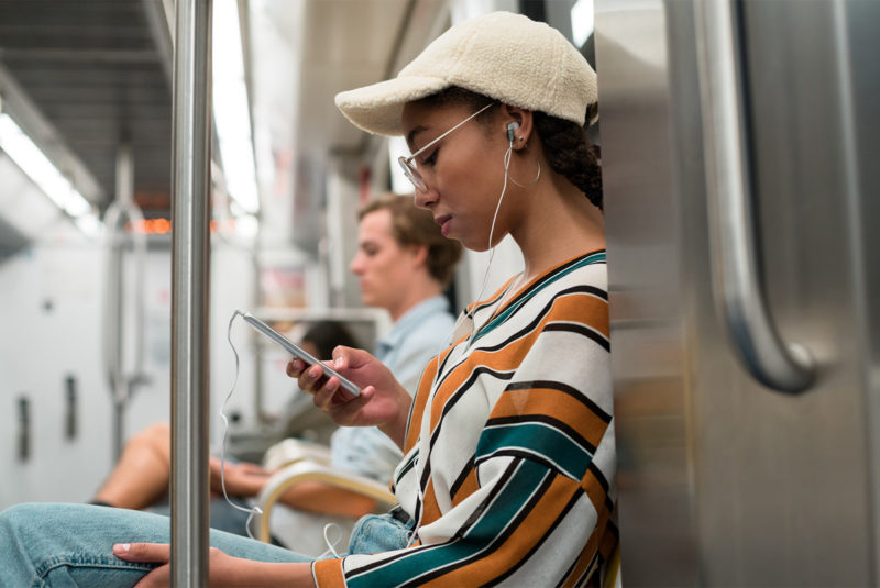 Young woman on subway looking at phone