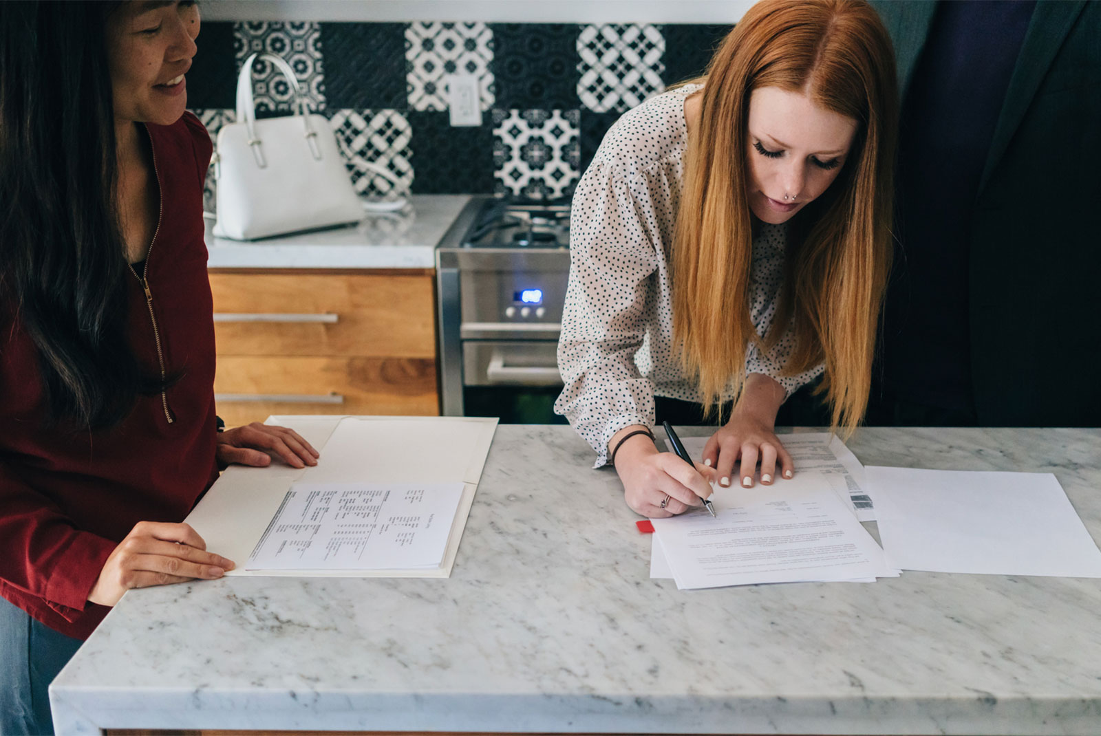 lady with red hair signing a contract reflecting concept buy a house with student loan debt