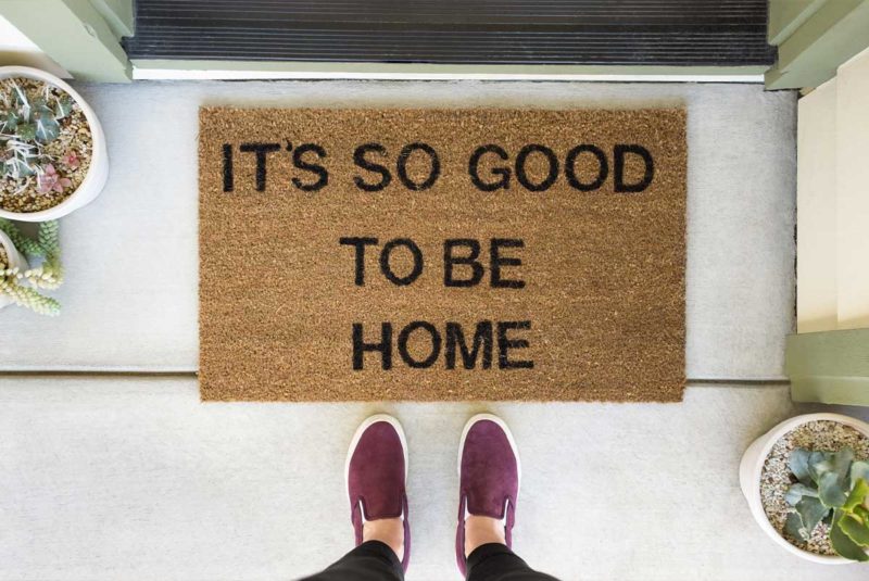 A downward view of a doormat that says, “It’s so good to be home"
