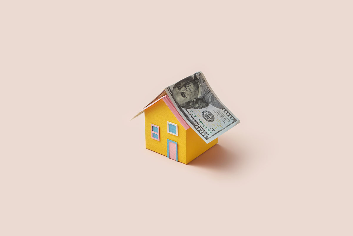 Yellow paper house with dollar as roof