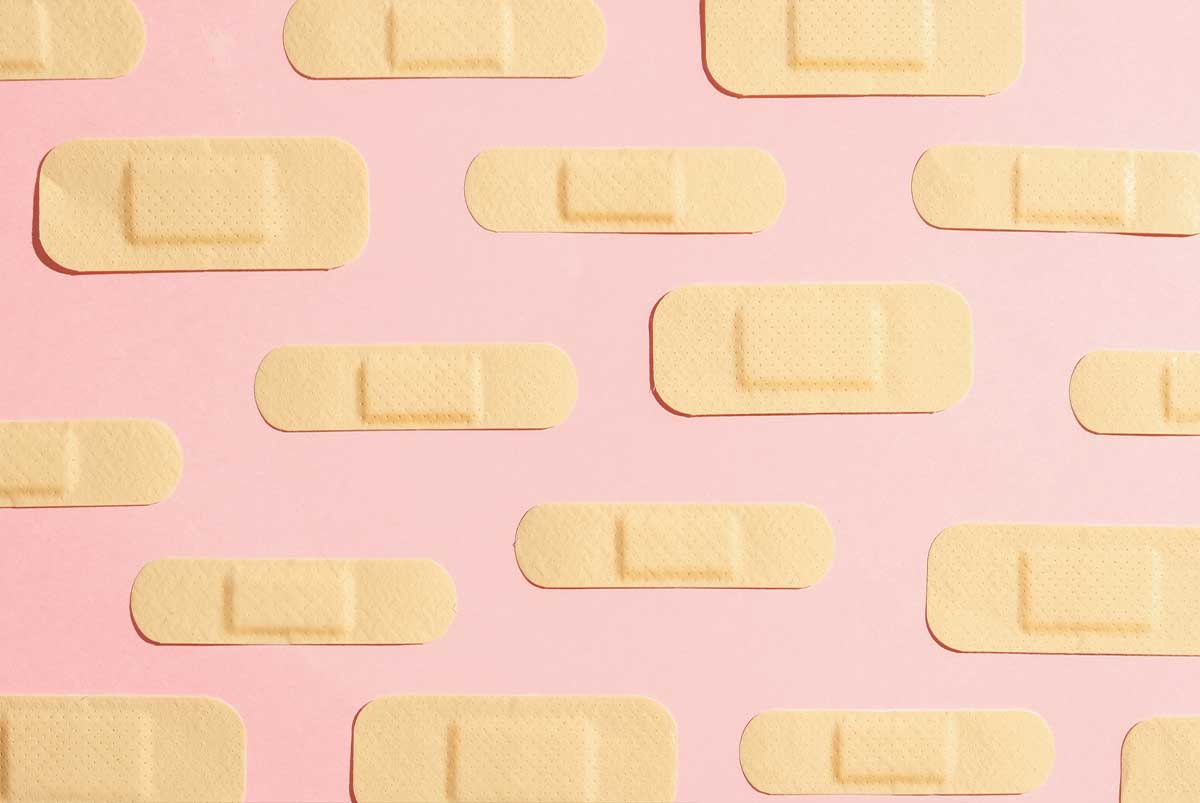 Rows of bandaids on pink background