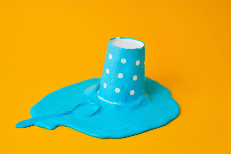 a blue cup with white spots and spilled icecream