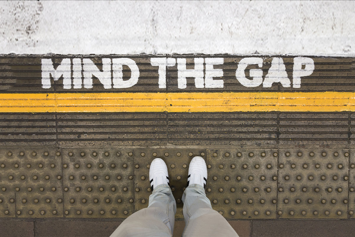 Mind the gap written on a subway station floor